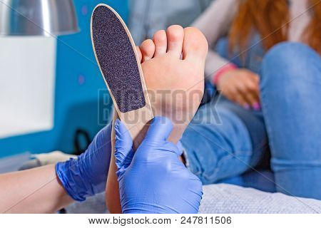 Master During A Pedicure. The Process Of Professional Pedicures. The Wizard In The Mask Causes The G