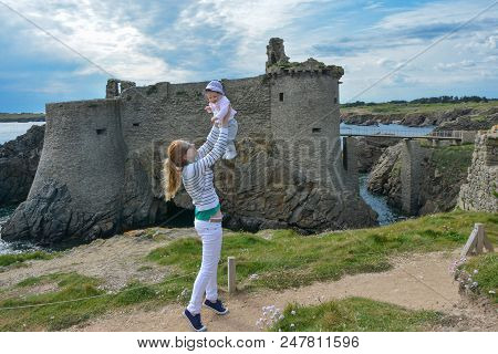 Happy Mother Throws Her Daughter In The Sky Near The Castle Of The Island Yeu, France