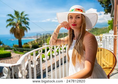 Beautiful Girl In A Shite Dress And Summer Hat Exploring The Old Town Of Taormina On Sicily Island.
