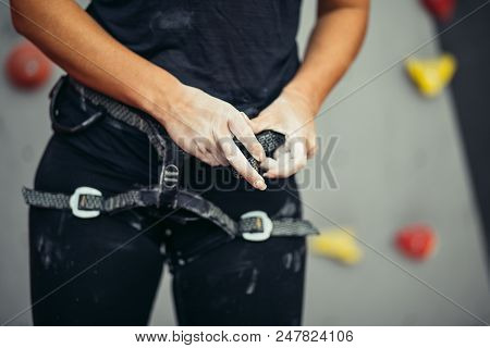 Close Up Of Unrecognizable Woman Arranging Harness On Her Waist In Climbing Gym. Climbing Equipment 