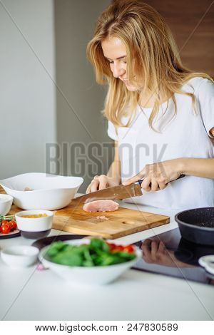 Woman Cutting Chicken Meat For Being Marinated Later. Young Cooker Doing Her Best To Satisfy Her Cho