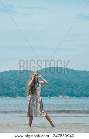 Handsome Girl On The Beach Background. Portrait Of A Woman In White Clothes On The Sea