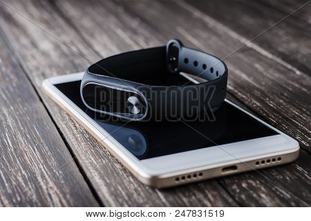 Fitness Tracker And Smartphone On Wooden Background Closeup