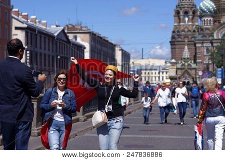 ST. PETERSBURG, RUSSIA - JUNE 20, 2018: Tunisian football fans with national flag at FIFA Fan Fest in Saint Petersburg during FIFA World Cup Russia 2018. The city host 7 matches of FIFA World Cup