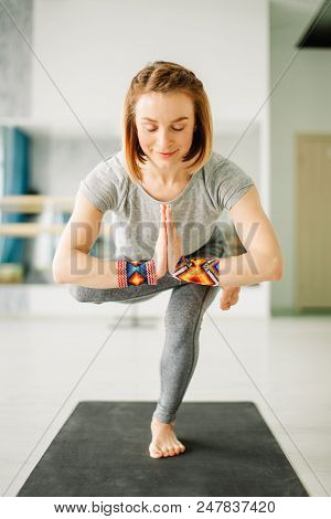 Close-up Of Charming Young Woman In A Black Suit Doing Sophisticated Yoga Exercise Stand On One Leg 