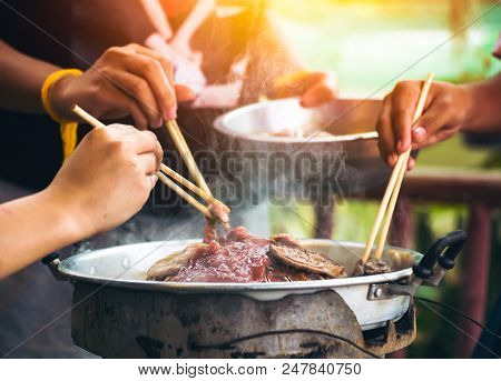People Cooking Meat And Grill. Food Are Vegeteble. People Use Chopsticks.