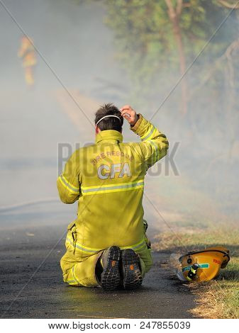 Melbourne, Australia - April 13, 2018: Exhausted Fire Fighter At A Bush Fire In An Suburban Area Of 
