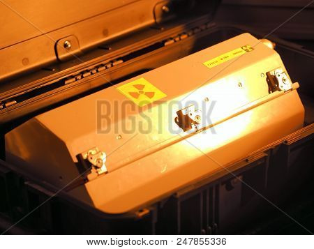 Box Shaped Metal Container With Radiation Warning In A Military Grade Transport Box Under Red Light