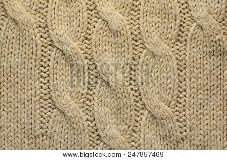 Knit Texture Of Beige Wool Knitted Fabric With Cable Knits Pattern. Blank Background