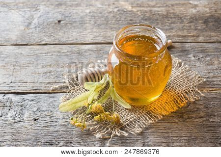 Glass Jar Of Honey, Linden Flowers On Wooden Background