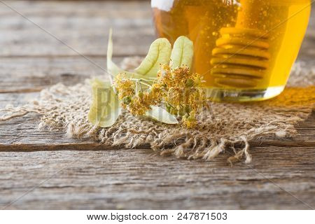 Glass Jar Of Honey, Linden Flowers On Wooden Background