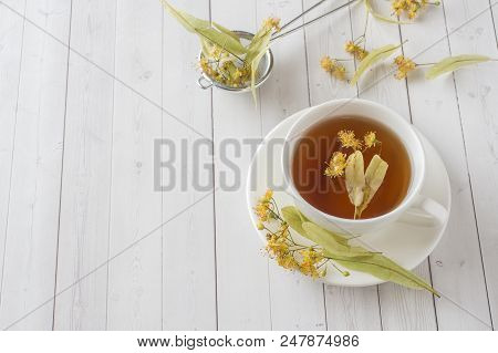 Cup Of Tea With Linden Flowers On A Light Table