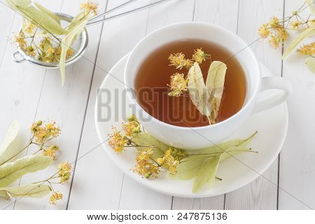 Cup Of Tea With Linden Flowers On A Light Table