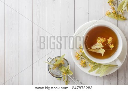 Cup Of Tea With Linden Flowers On A Light Table