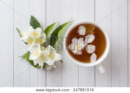 Mug Of Herbal Tea With Petals Of Jasmine Flowers On A Light Background
