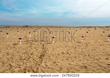 Deserted Beach In Winter With Sand And Umbrellas Supports. Caorle - Venice - Veneto - Italy - Europe