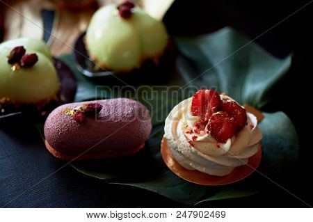 Moscovie Cakes Purple And Lemon Yellow. Pistachio And Fruit. Culinary Art. Gold Leaf Monstera