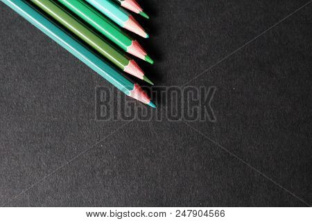 Creativity And Environment Concept: Green Colored Pencils, Black Background, Selective Focus