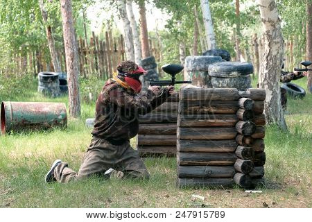 Landfill In The Woods For Extreme Sports. A Guy Or Girl In A Protective Suit Peeks Out From Behind A