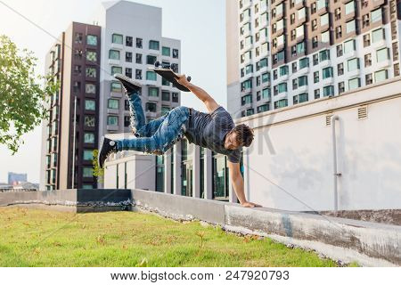 Skateboarder Handstand On Ramp On The Sunset.