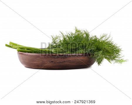 A Bunch Of Fresh Dill Is Lying On The Wooden Plate, Situated On The White Background.
