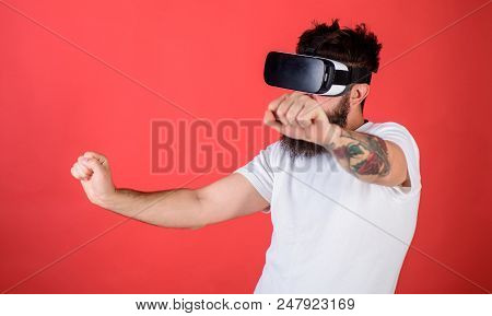 Virtual Racing Concept. Man With Beard In Vr Glasses Driving Motorbike, Red Background. Hipster On C