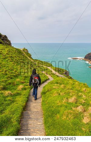 Tintagel, United Kingdom - May 02, 2014: View Of Tintagel Island With Tourist On The Path On The Cor