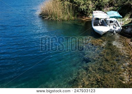 Tour Boats Docked At Shoreline Above Steep Drop Off Into Lake Cuicocha In Ecuador