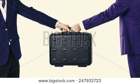 Male Hands In Suits Hold Black Briefcase. Business Exchange Concept. Handover Of Case In Hands Of Bu