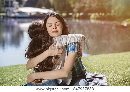 Cheerful Picture Of Mother And Daughter Embracing Each Other. Woman Is Keeping Eyes Closed. She Is V
