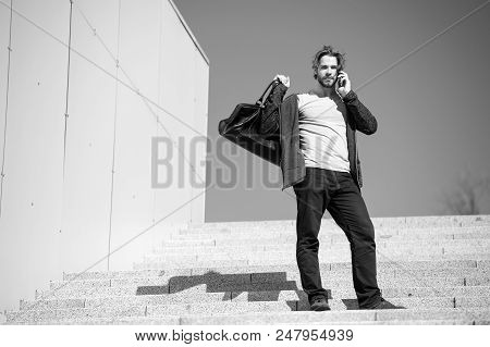 Guy Talk On Mobile Phone At Stair On Blue Sky. Man With Bag, Smartphone On Steps On Sunny Day. Vacat