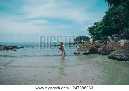 Handsome Girl On The Beach Background. Portrait Of A Woman In White Clothes On The Sea