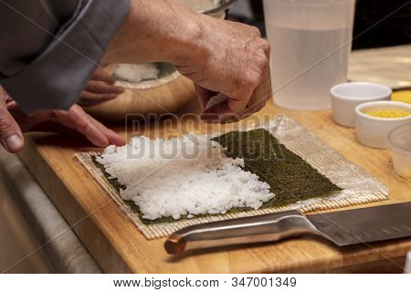Chef Preparing Ingredients And Teaching How To Make Sushi