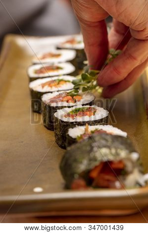 Sushi Roll Being Sliced In A Demonstaration Class