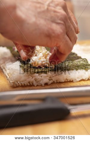 Sushi Roll Demonstration On How To Place Ingredients For An Outside Sushi Roll, With Rice And Seawee