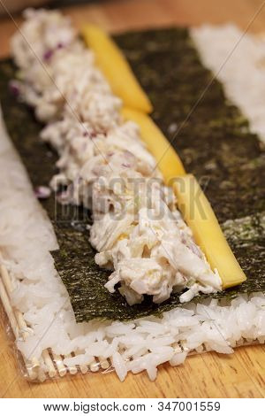 Sushi Roll Demonstration On How To Place Ingredients For An Outside Sushi Roll, With Rice And Seawee