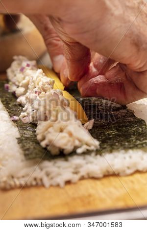Sushi Roll Demonstration On How To Place Ingredients For An Outside Sushi Roll, With Rice And Seawee