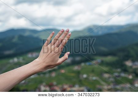 Female Hand On Naturebackground. Reach The Mountains. Travel Manicure.