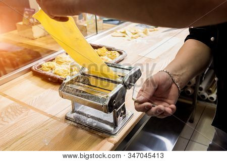 Chef Rolling Dough With A Pasta Machine. Pasta Maker Machine.