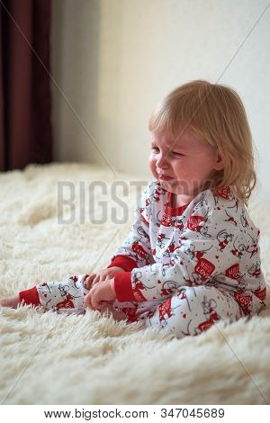 Little Girl Sitting On The Bed Crying