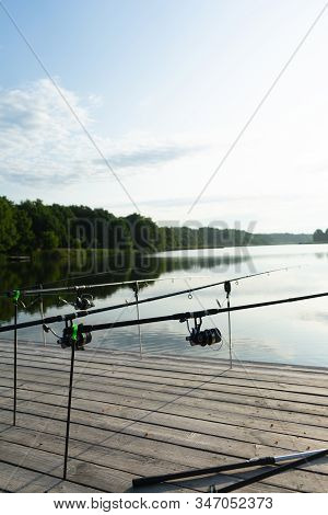 Carp Fishing On Beautiful Blue Lake With Carp Rods And Rod Pods In The Summer Morning. Fishing From 