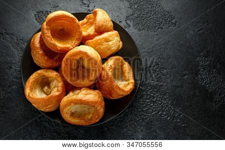 Traditional English Yorkshire Pudding Side Dish On Black Plate And Background