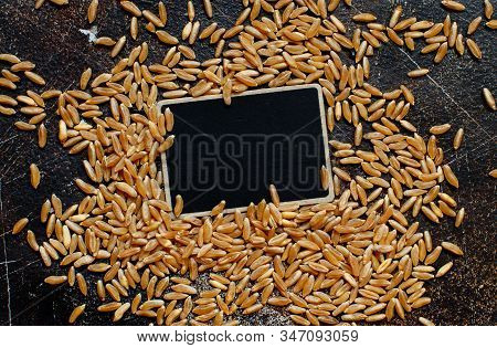 Raw Kamut Grain With A Small Chalkboard Top View