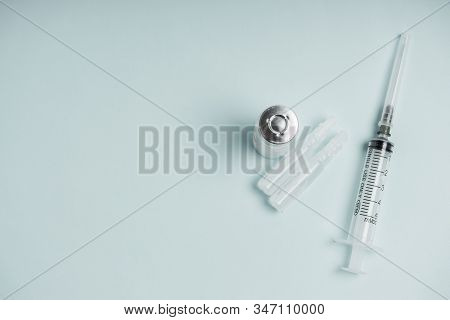 Medicine Bottle With Vaccine And Disposable Syringe Closeup On Blue Background. Health Pharmacy Phar