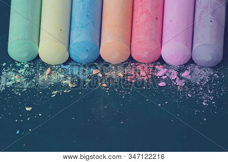 Crumbs And Chunks Of Multicolored Chalk, Pastels On The School Board. Yellow, Pink, Red, Green, Gray
