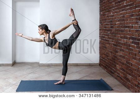 Side View Portrait Of Brunette Young Woman Wearing Sport Clothes Working Out Against White Wall, Doi