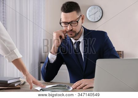 Woman Offering Bribe To Man At Table In Office