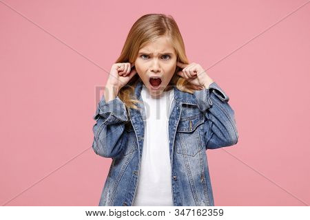Shocked Little Kid Girl 12-13 Years Old In Denim Jacket Isolated On Pastel Pink Background In Studio