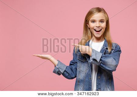 Cheerful Little Blonde Kid Girl 12-13 Years Old In Denim Jacket Isolated On Pastel Pink Wall Backgro