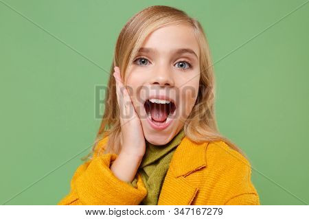 Close Up Of Little Kid Girl 12-13 Years Old In Yellow Coat Posing Isolated On Green Background. Chil